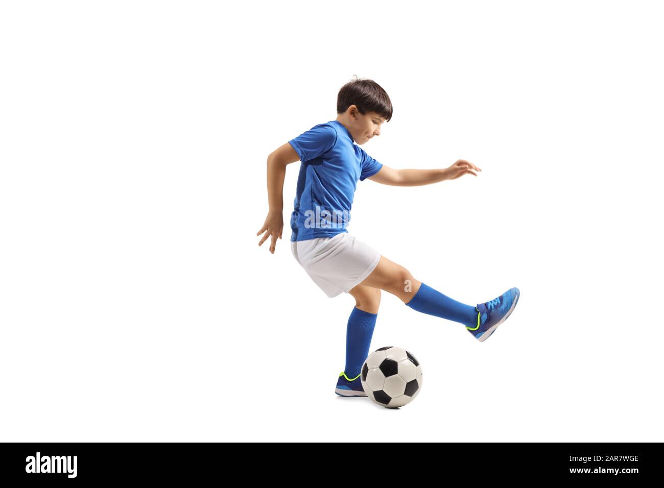 Lange Aufnahme eines Jungen, der einen auf weißem Hintergrund isolierten Fußballball treibt Stockfoto
