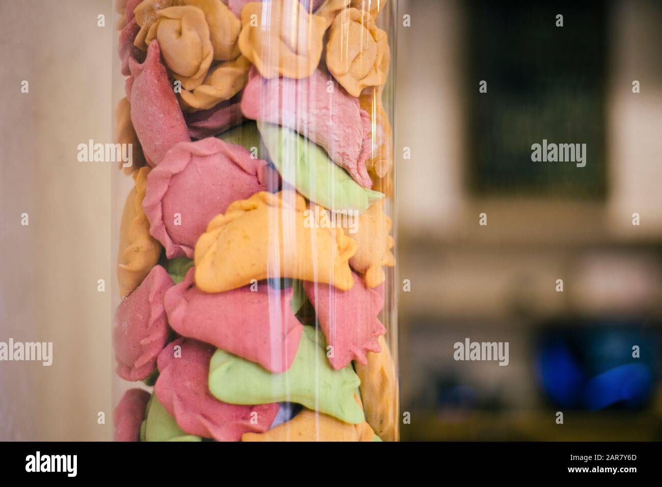 Rohe bunte Knödel oder Vareniken in Glasbehältern, traditionelle russische und ukrainische Küche. Stockfoto