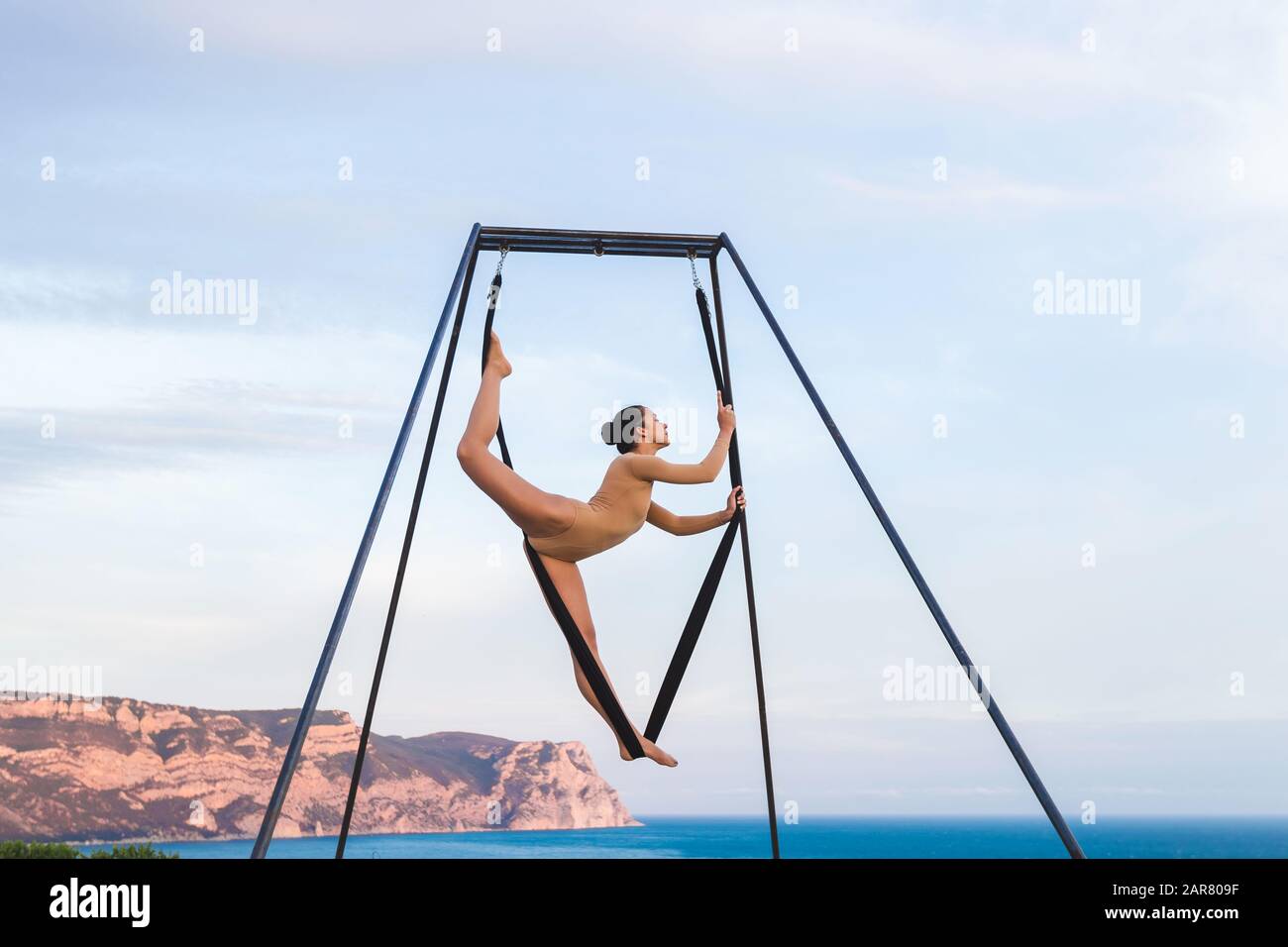 Akrobatische Fly Dance Yoga im Freien mit Blick auf die Berge. Sport und gesundes Wohnkonzept Stockfoto
