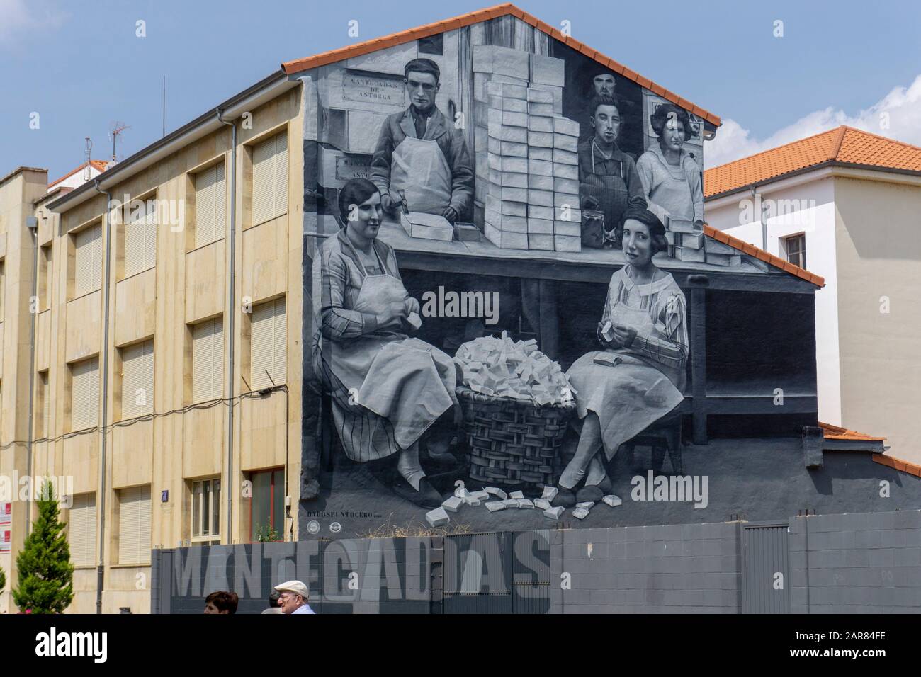 Großes Wandbild in Schwarzweiß, das Männer und Frauen darstellt, die in einem Geschäft an der Seite eines Gebäudes in Astorga in Galicien, Spanien, arbeiten Stockfoto