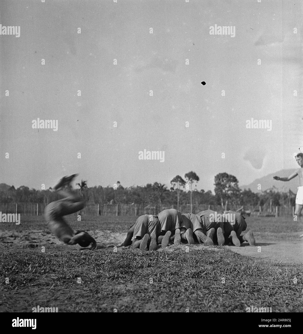 Ausbildungsinfanteriedepot KNIL Rantepao (Celebes) Rantepao, eine Stadt in den mittleren Celebes [Hauptstadt der Toradja-Länder] hat nur den Namen des dortigen Ausbildungsinstituts erhalten. Besondere Aufmerksamkeit gilt der unbewaffneten Selbstverteidigung durch die Rekruten. Einer der Rekruten taucht über 5 kniende Kameraden ein und kommt mit einer Kopfwalze zurück auf seine Füße Datum: 4. November 1948 Ort: Indonesien, Niederländische Ostindien Stockfoto