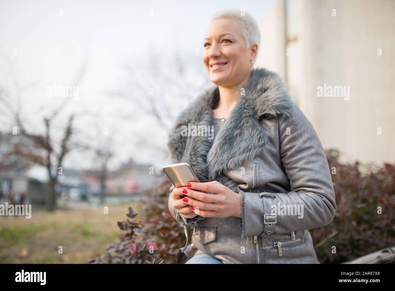 Frau auf der Straße benutzt ein Handy Stockfoto