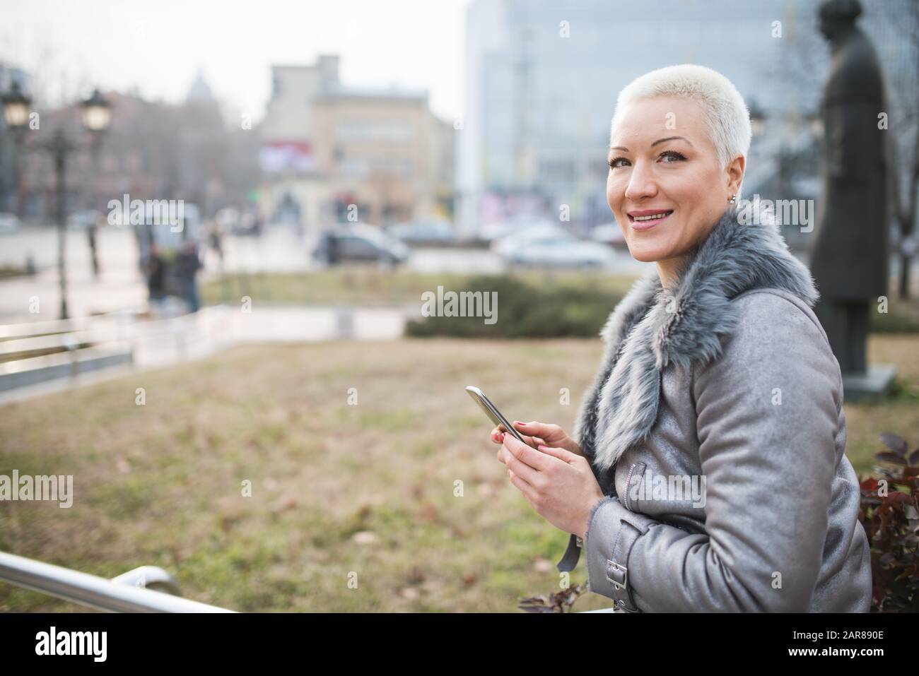Frau auf der Straße benutzt ein Handy Stockfoto