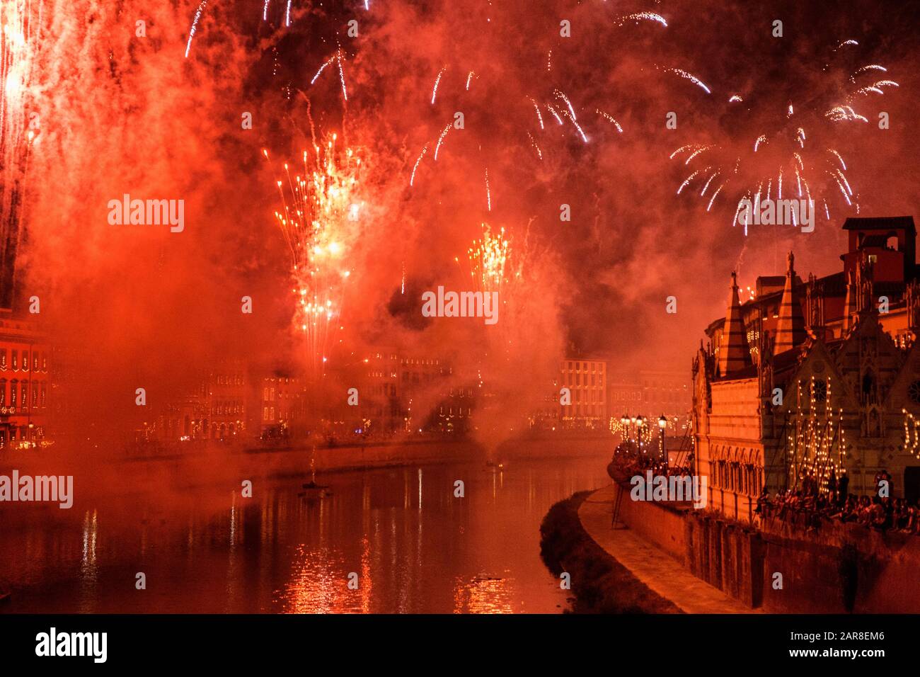 Bunte Feuerwerke erhellen den Himmel über dem Arno-Fluss und ehren den Heiligen San Ranieri, Luminaria-Festival, am 16. Juni in Pisa, Italien Stockfoto