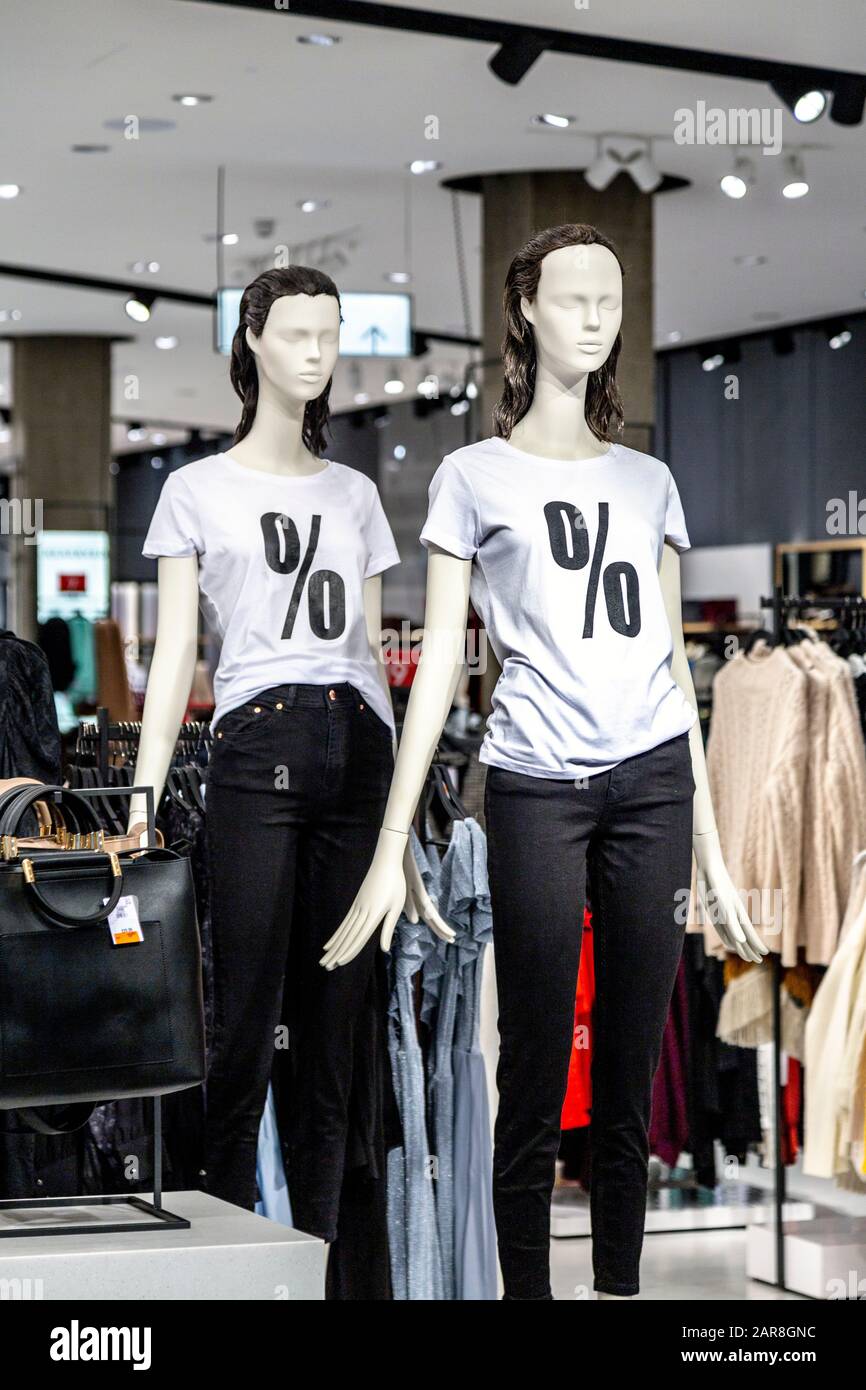 Schaufensterpuppen in einem Bekleidungsgeschäft mit Verkaufsschild auf T-Shirts Stockfoto