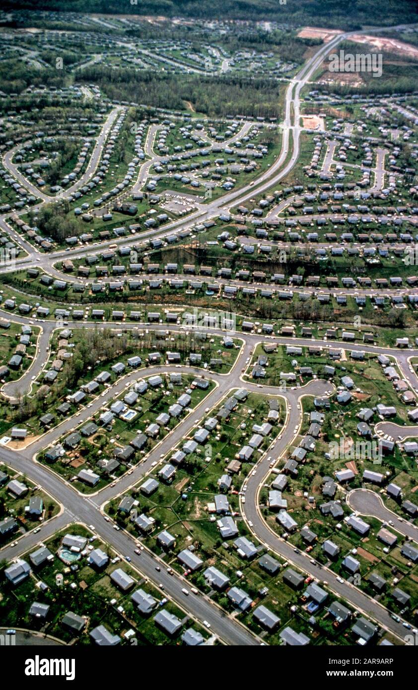 Einfamilienhäuser mit grünem Rasen säumen mäandernde Straßen in der geplanten Vorstadt Woodbridge, VA. Stockfoto