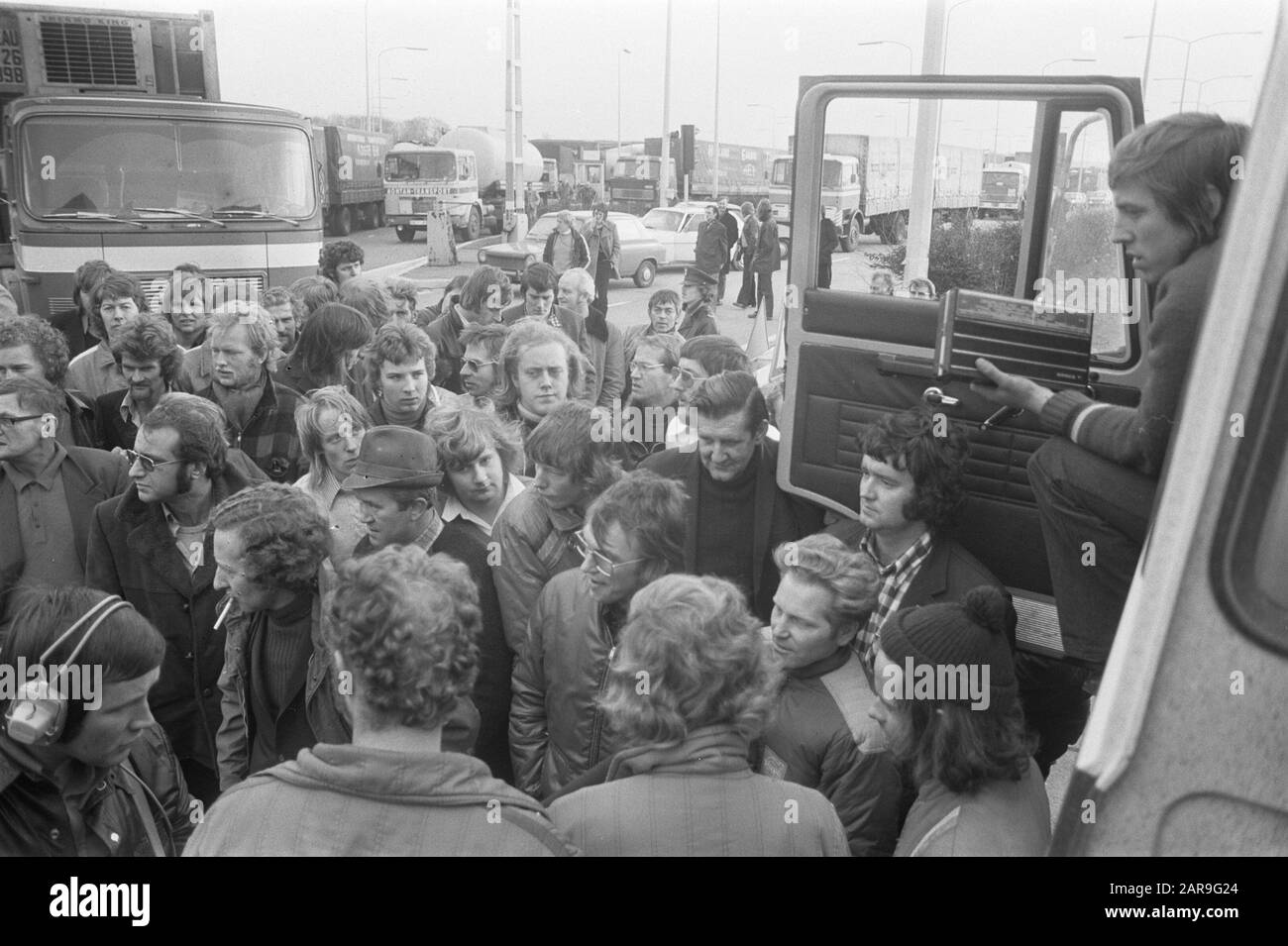 LKW-Fahrer blockieren den Grenzübergang aus Protest gegen obligatorischen Fahrtenschreiber (Grenzpost Bergh); LKW-Fahrer hören sich Nachrichtenberichte/Datum an: 26. November 1974 Standort: Bergh, Gelderland, Montferland Schlüsselwörter: Fahrer, LASTWAGEN, Grenzübergänge, Proteste, Tachogramme Stockfoto