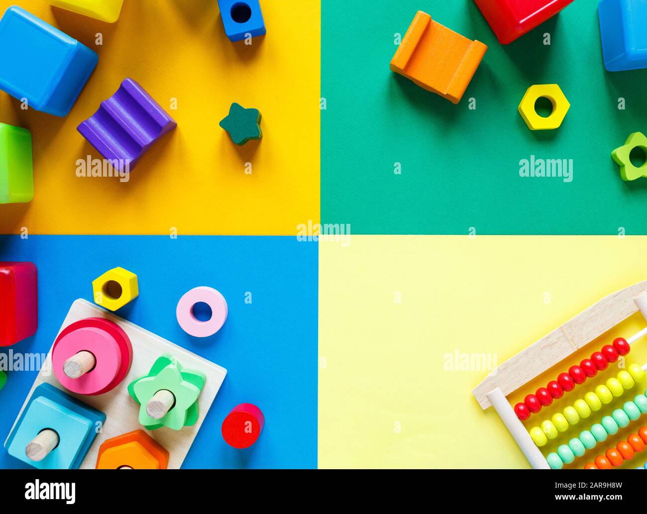 Holzspielzeug für Kinder auf farbenfrohem Papier. Spielzeugblöcke für Bildungseinrichtungen. Spielzeug für Kindergarten, Vorschule oder Kindertagesstätte. Platz für Text kopieren. Draufsicht Stockfoto