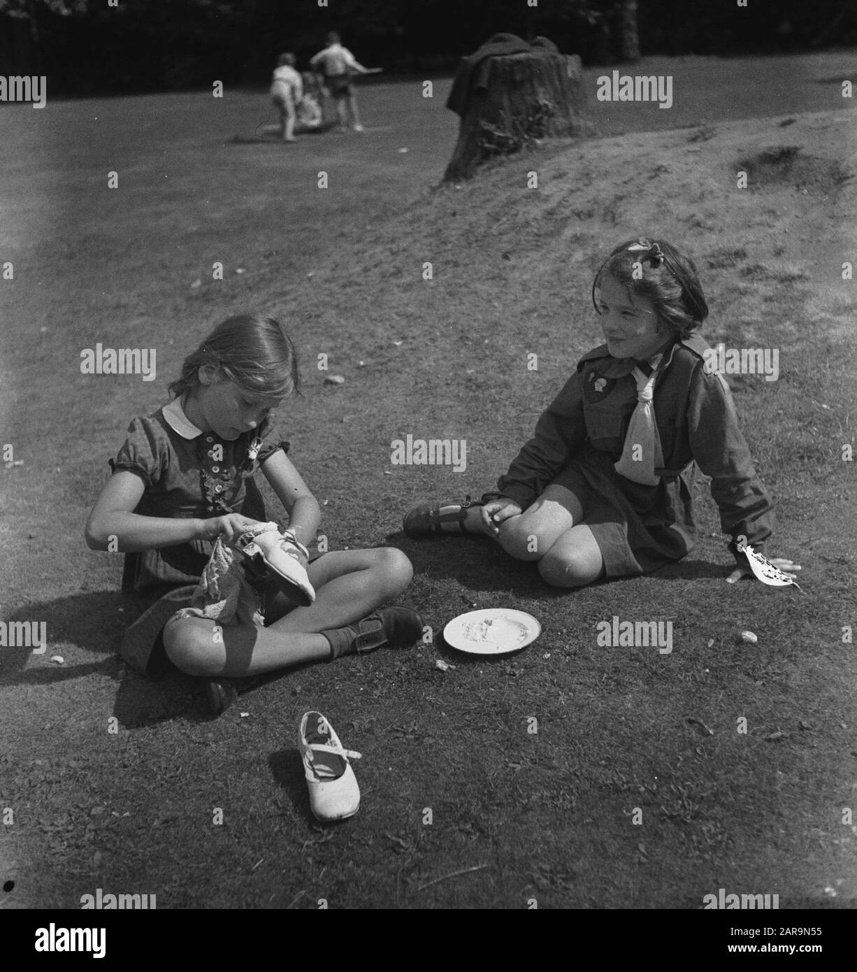 [Sommerlager Niederländische Kinder?] [zwei Mädchen auf dem Rasen] Anmerkung: Das Mädchen auf der rechten Seite trägt eine Pfadfinderuniform Datum: 1943 Ort: Großbritannien Schlagwörter: Kinder, zweiter Weltkrieg Stockfoto