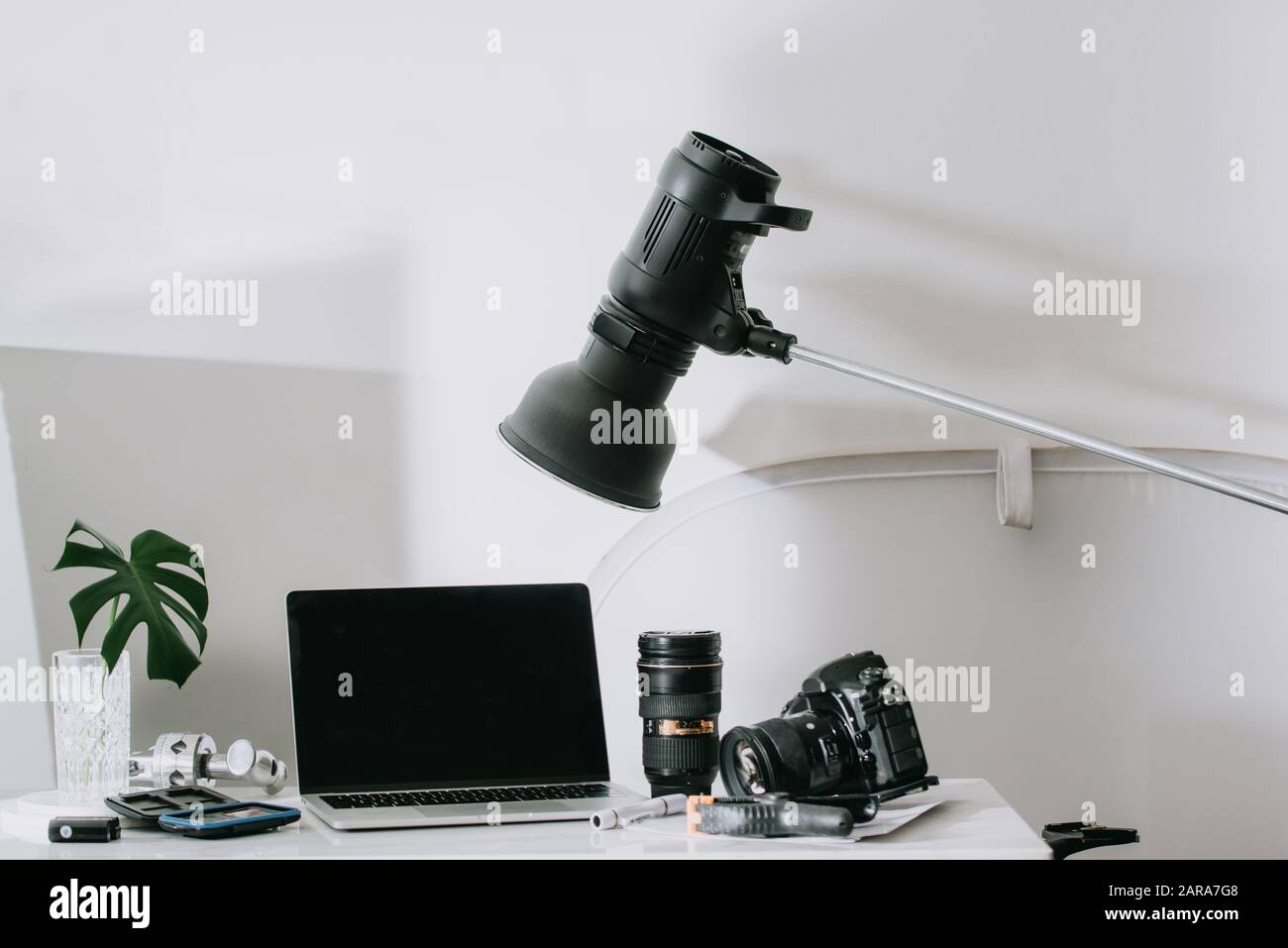 Immer noch leben, Arbeit von zu Hause aus Ausflüge mit professionellen Fotoausrüstung, Kamera, Objektiv, computer monitor, Elektronik drinnen. Stockfoto