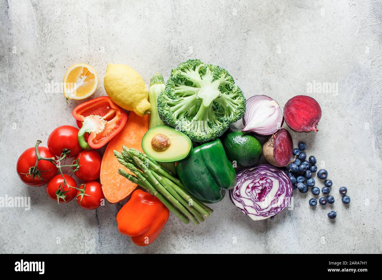 Rainbow färbt frisches Gemüse und Beerenhintergrund. Detox, veganes Essen, Zutaten für Saft und Salat. Stockfoto