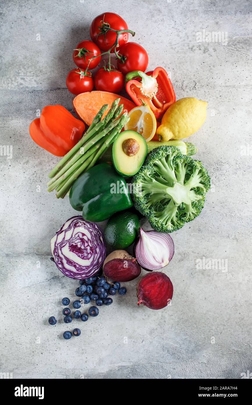 Rainbow färbt frisches Gemüse und Beerenhintergrund. Detox, veganes Essen, Zutaten für Saft und Salat. Stockfoto