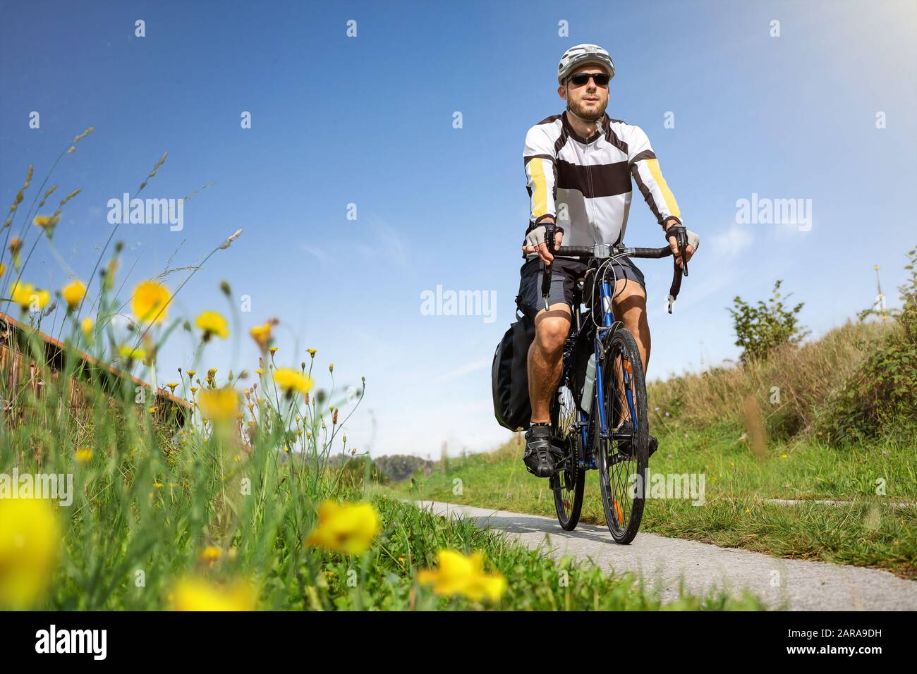 Mann, der an einem sonnigen Tag im Frühling mit dem Fahrrad unterwegs ist Stockfoto
