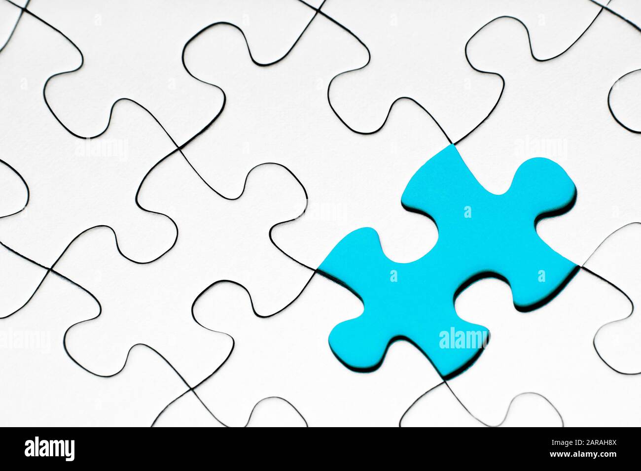 Hellblaues Puzzleteil dazwischen aus weißen Puzzleteilen, Geschäftskonzept Stockfoto