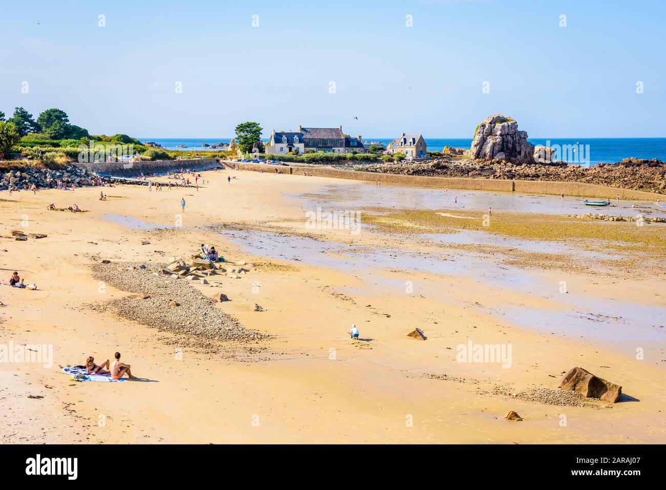 Der sandige Strand und der kleine Hafen von Pors Hir bei Ebbe in der Gemeinde Plougrescant in der nördlichen Bretagne, Frankreich, an einem sonnigen Sommertag. Stockfoto