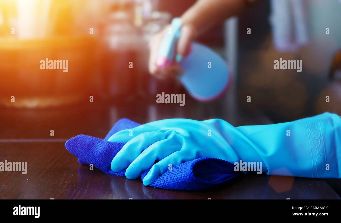 Hand in blauem Gummihandschuh mit blauem Mikrofaser-Reinigungstuch und Sprühflasche mit Sterilisationslösung für eine gute hy-reinigung und Desinfektion Stockfoto