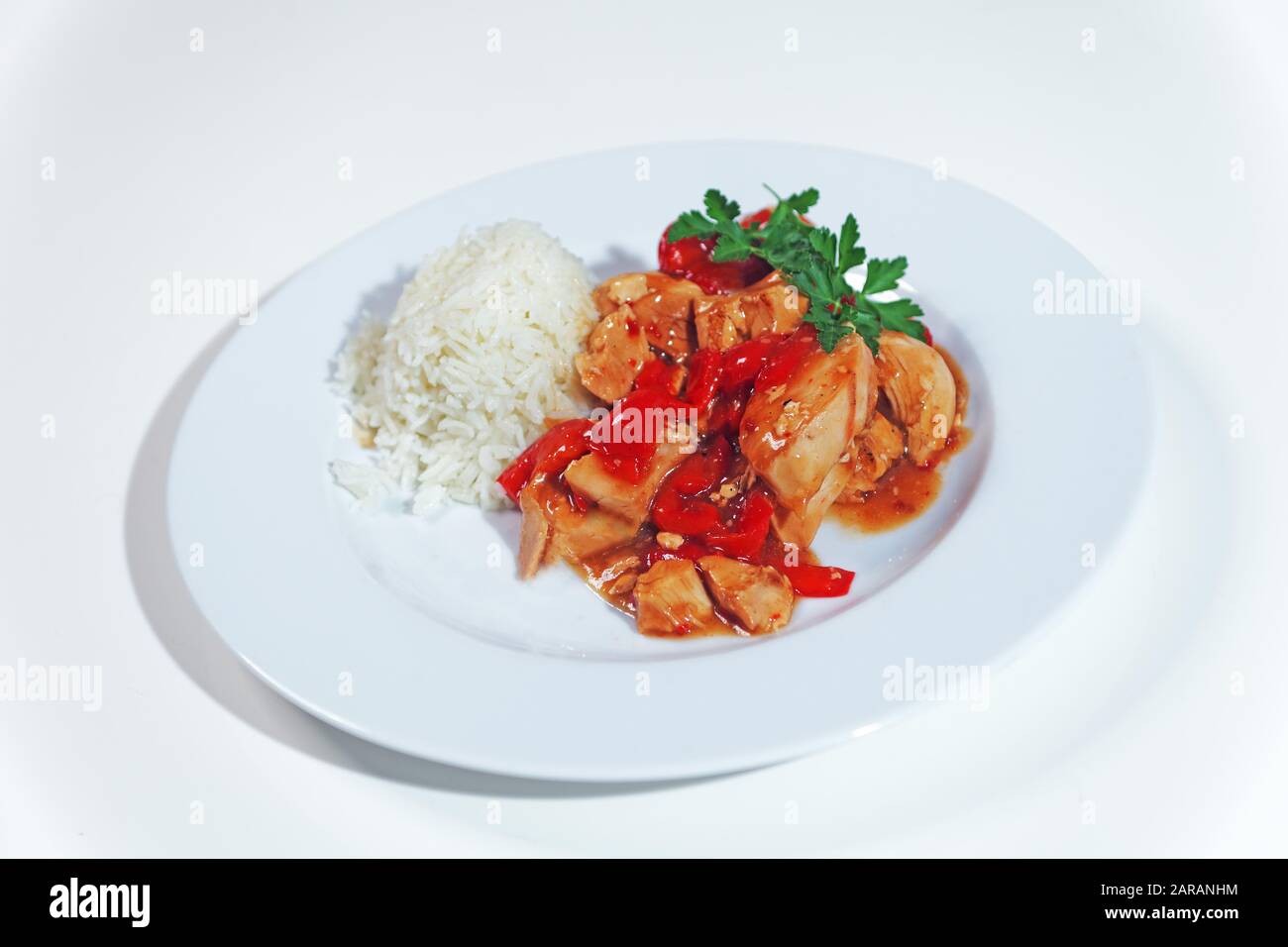 Paprikahuhn mit Reis auf dem Teller Stockfoto