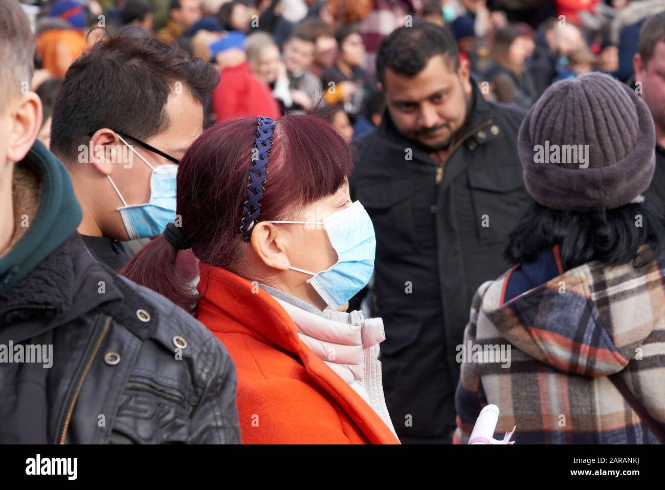 Menschenmassen Feiern Das chinesische Neujahr 2020 auf dem Trafalgar Square London Chinesisches Paar mit Gesichtsmasken in der Menge Stockfoto