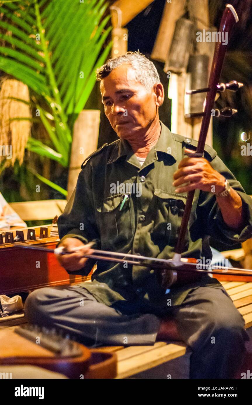 Musiker spielt ein Tro, möglicherweise Tro Sau Toch, eine traditionelle kambodschanische Geige. Stockfoto