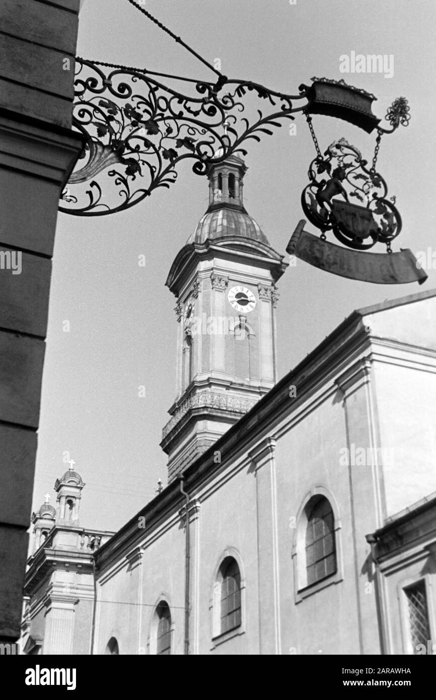 Kneipenschild Höllbräu mit dem Turm der St. Oswald-Kirche, 1957. Kneipschild Höllbräu mit St. Oswalds Kirchturm, 1957. Stockfoto