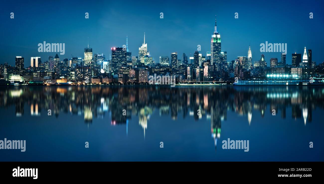 Blick von der Stadt Jersey aus während der blauen Stunde auf die Skyline von Manhattan. Skyline von New York bei Nacht mit Reflexionen. Stockfoto