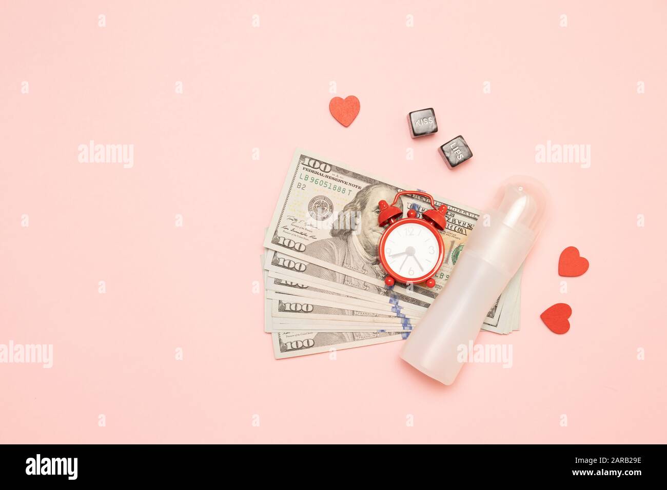 Viel Geld, Wecker, würfelförmige Einrichtung und Schmiermittel auf pinkfarbenem Hintergrund. "Love for Money"-Konzept Stockfoto