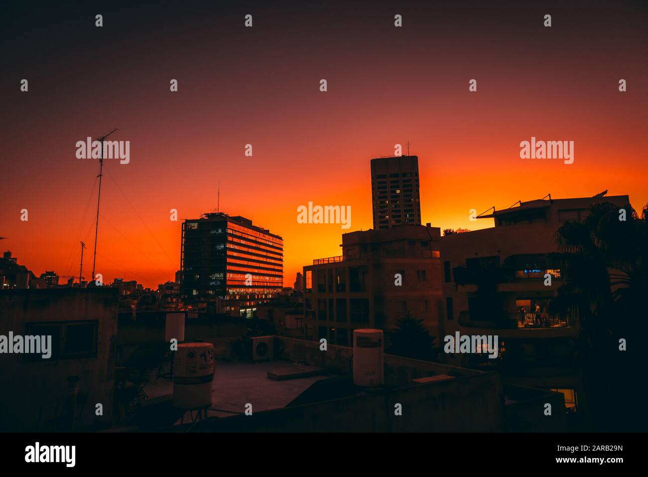 Stadtbild mit rotem Hintergrund bei Sonnenuntergang (Fotografiert in Tel Aviv, Israel. Rathaus im Zentrum) Stockfoto