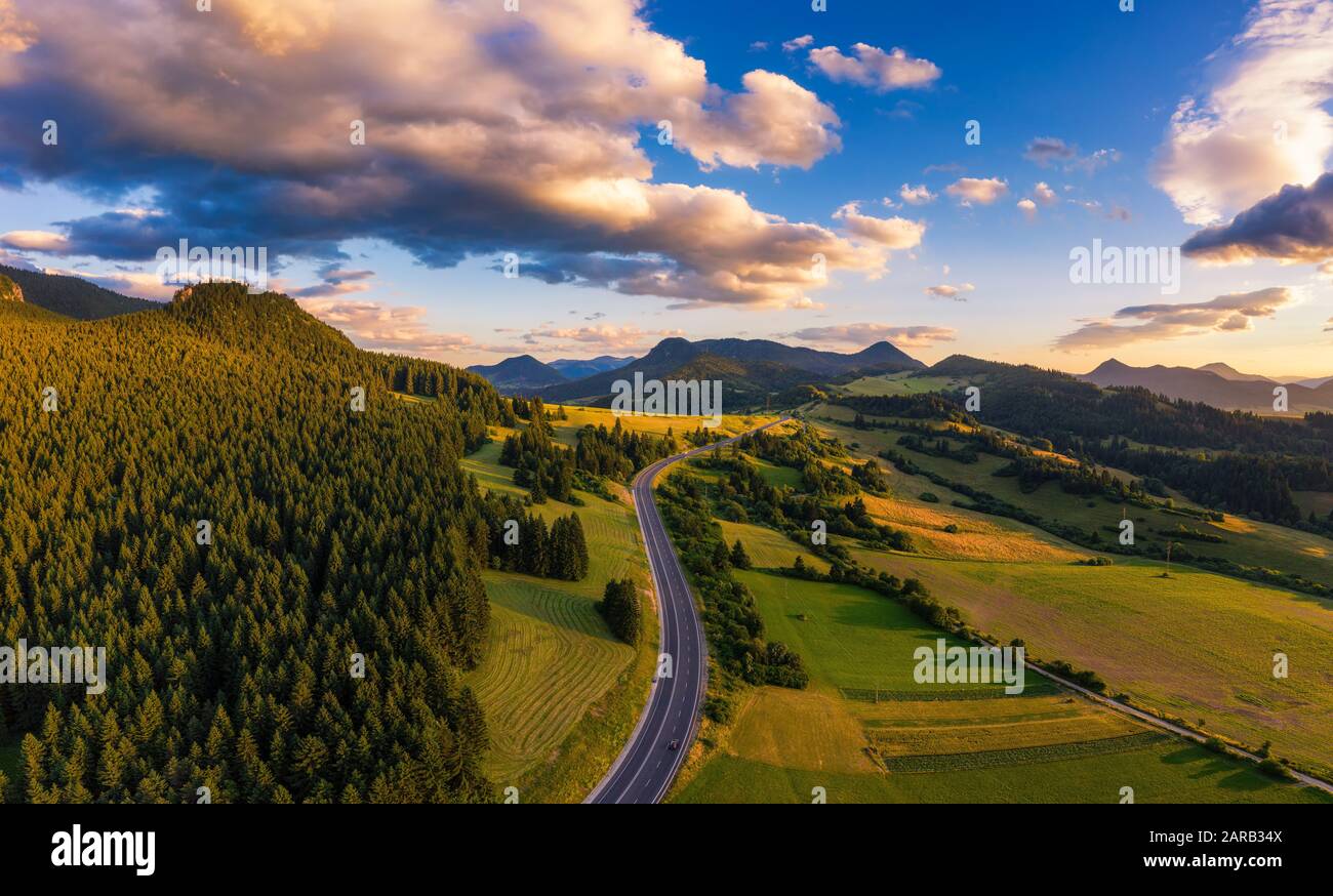 Straße, die bei Sonnenuntergang durch Wälder der Region Liptov in der Slowakei führt Stockfoto