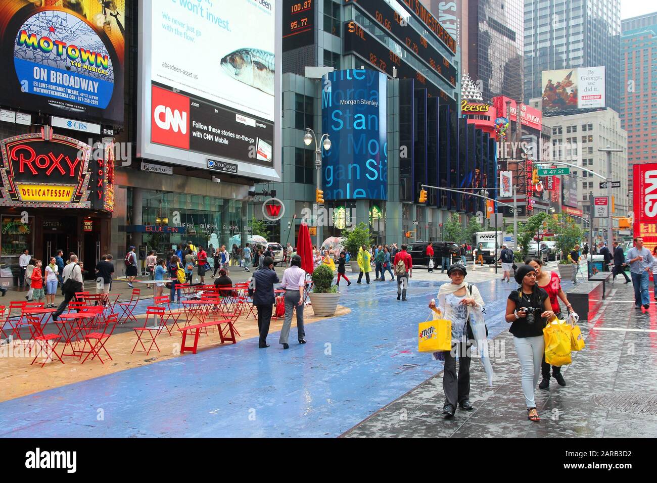 NEW YORK, USA - 10. JUNI 2013: die Menschen besuchen regnerischen Times Square in New York. Den Platz an der Kreuzung von Broadway und 7. Avenue hat einige 39 Millionen visi Stockfoto