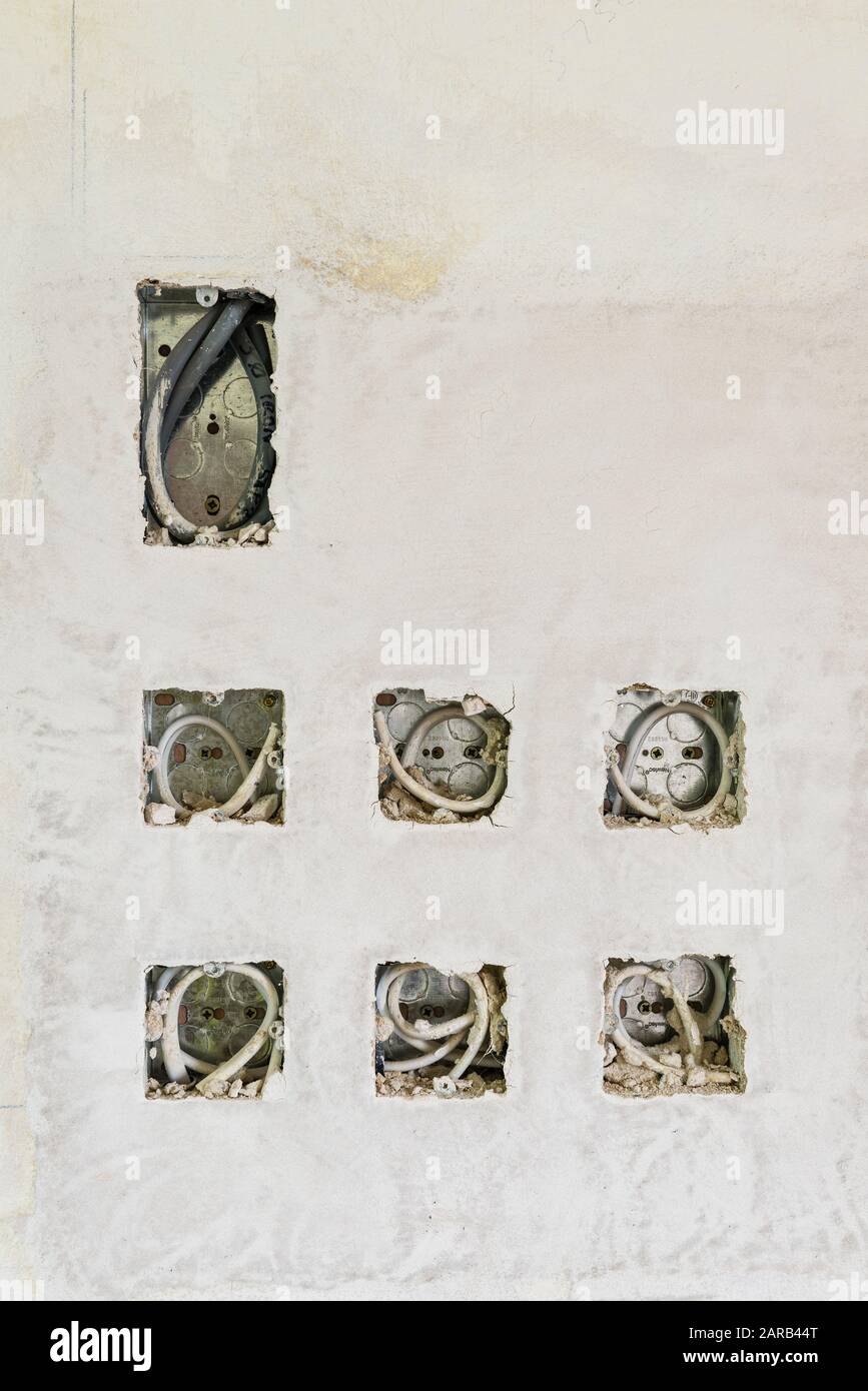 Verzinkte Metall-Rückenkästen (Spülkästen oder Wandkästen) für Lichtschalter, die in einem Haus, das gerade renoviert und neu verdrahtet wird, in eine Wand gesetzt werden Stockfoto