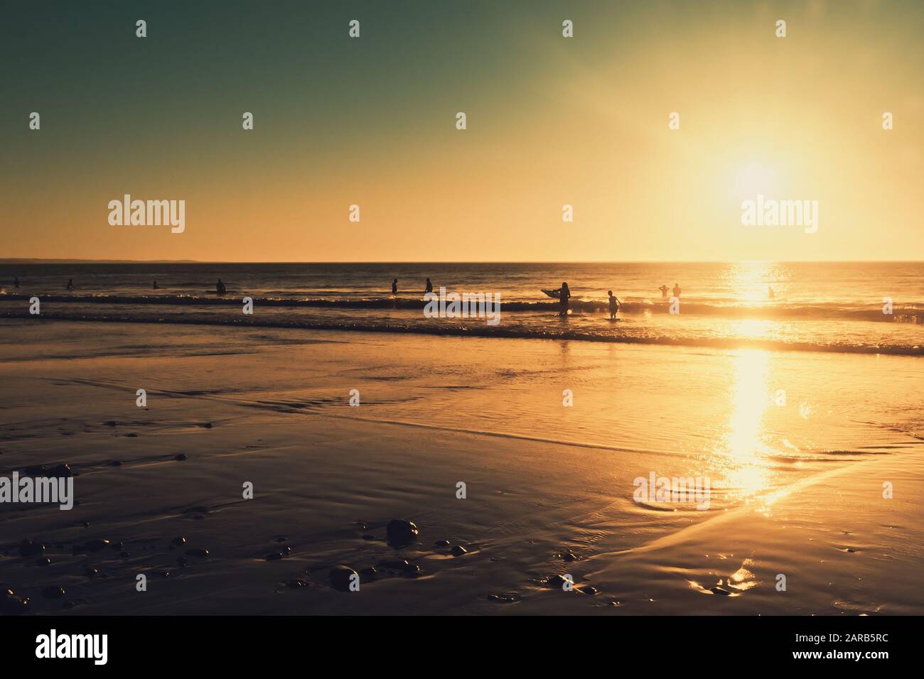 Menschen schwimmen im Meer bei Sonnenuntergang, Moana Beach, South Australia Stockfoto