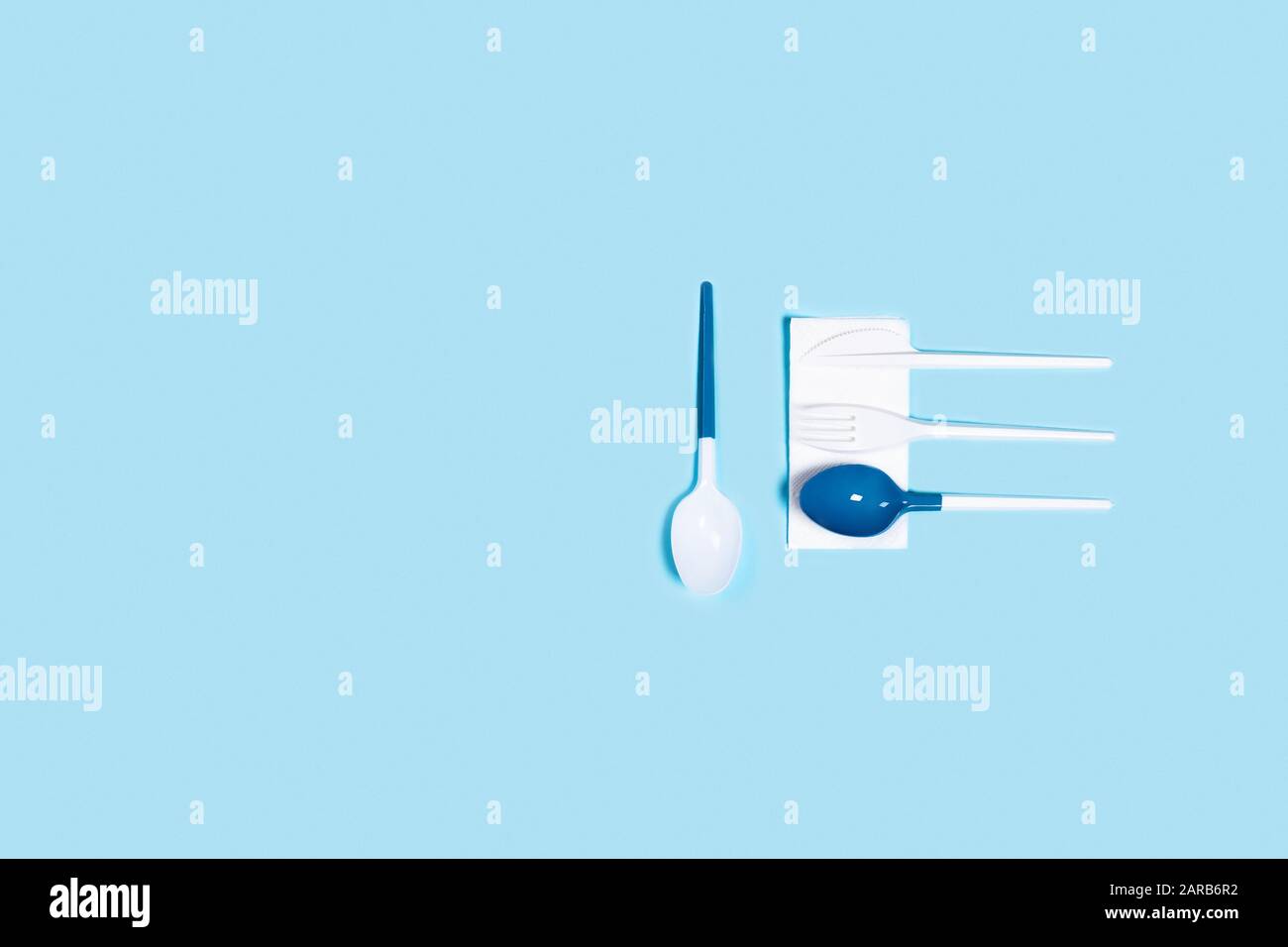 Abbildung der weißen Kunststofflöffel auf blauem Hintergrund. Flache Lage, Draufsicht. Stockfoto