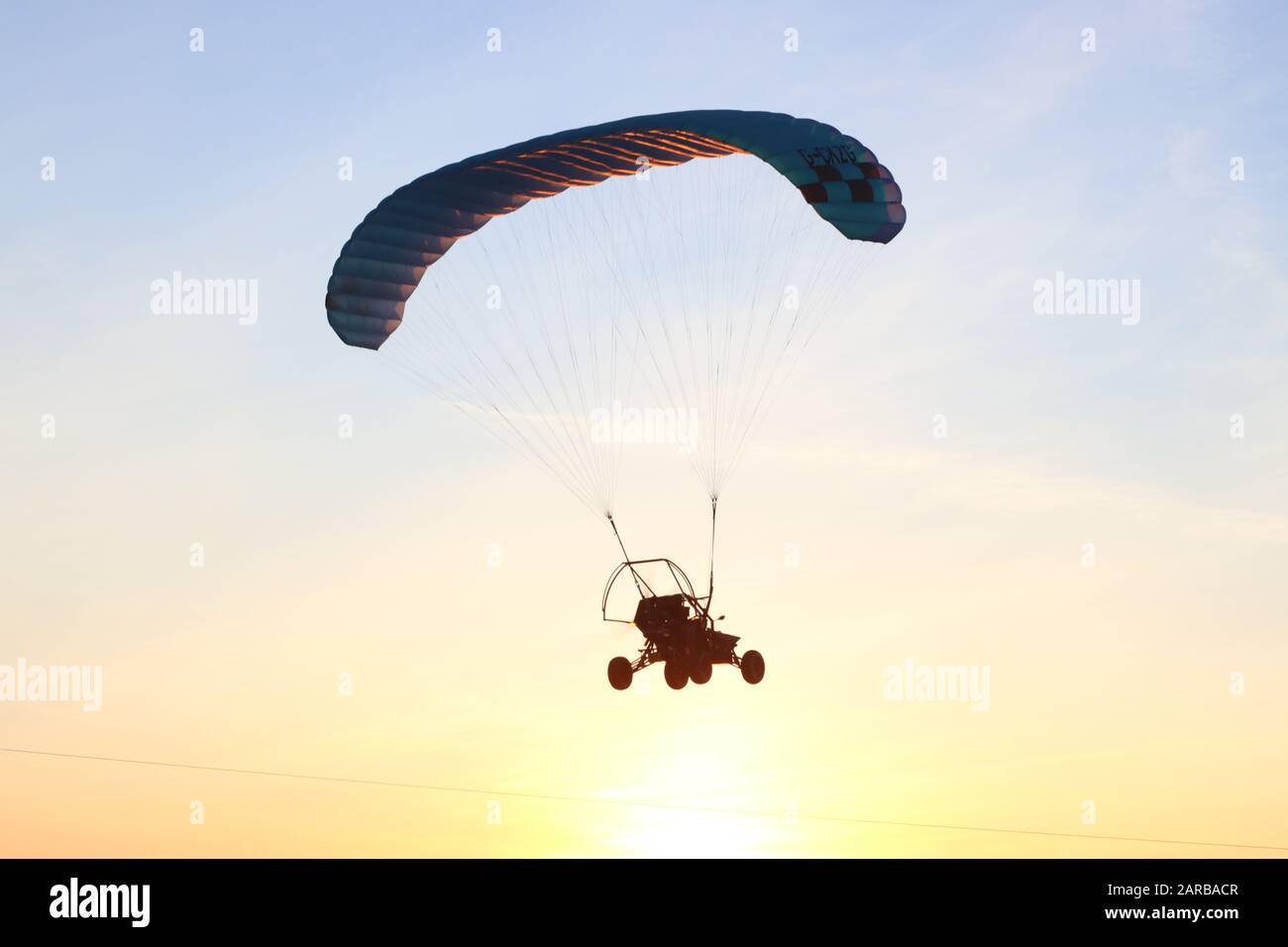 Auto, das an einem Winterabend in den Sonnenuntergang fliegt Stockfoto