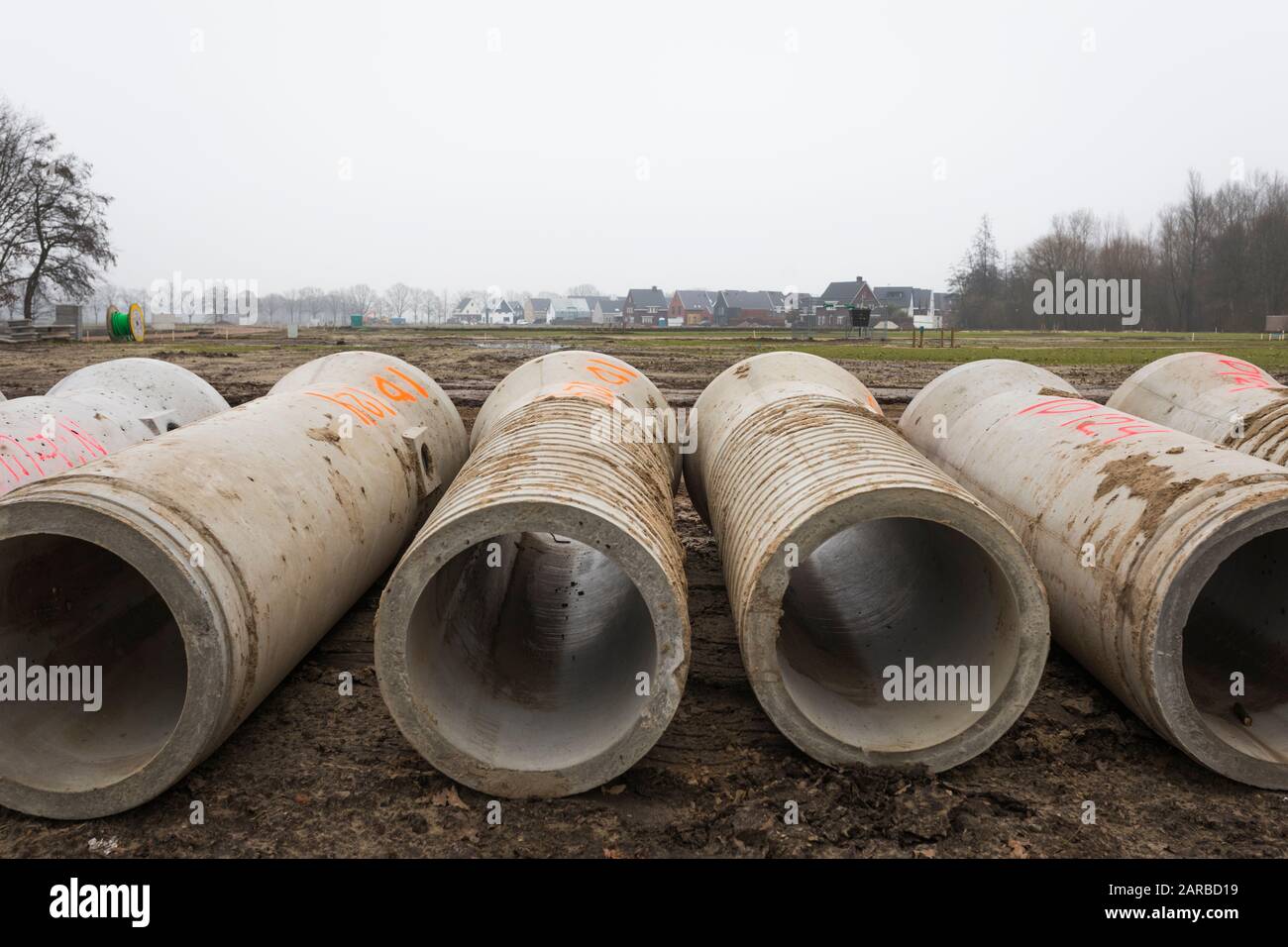 Betonabwasserkanalrohre für Bodenarbeiten am neuen Gebäudestandort in den Niederlanden Stockfoto