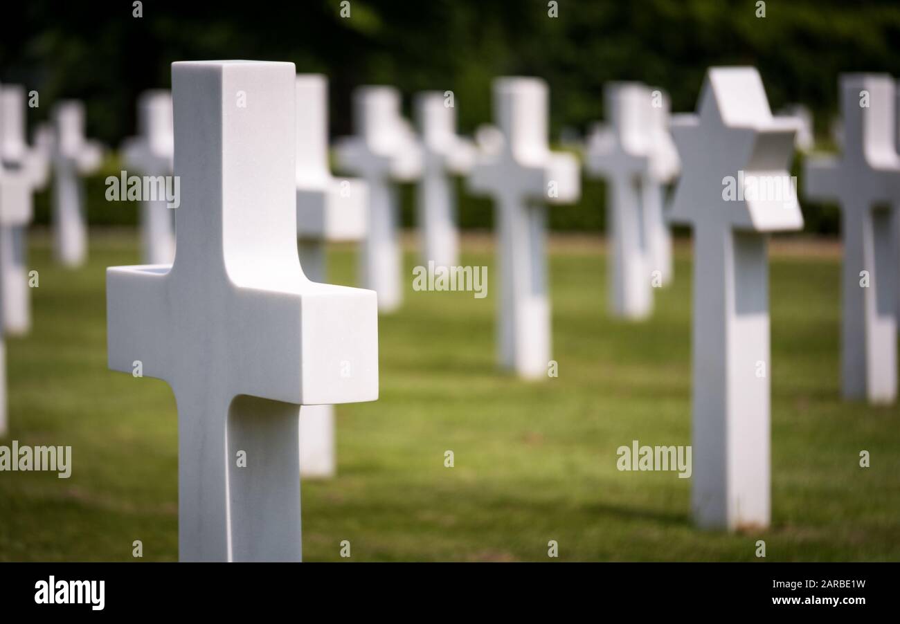 Grabsteine auf dem amerikanischen Friedhof. Schwerpunkt auf dem vorderen Kruzifix-Kopfstein mit dem jüdischen Davidstern dahinter. Cambridge, Großbritannien. Stockfoto