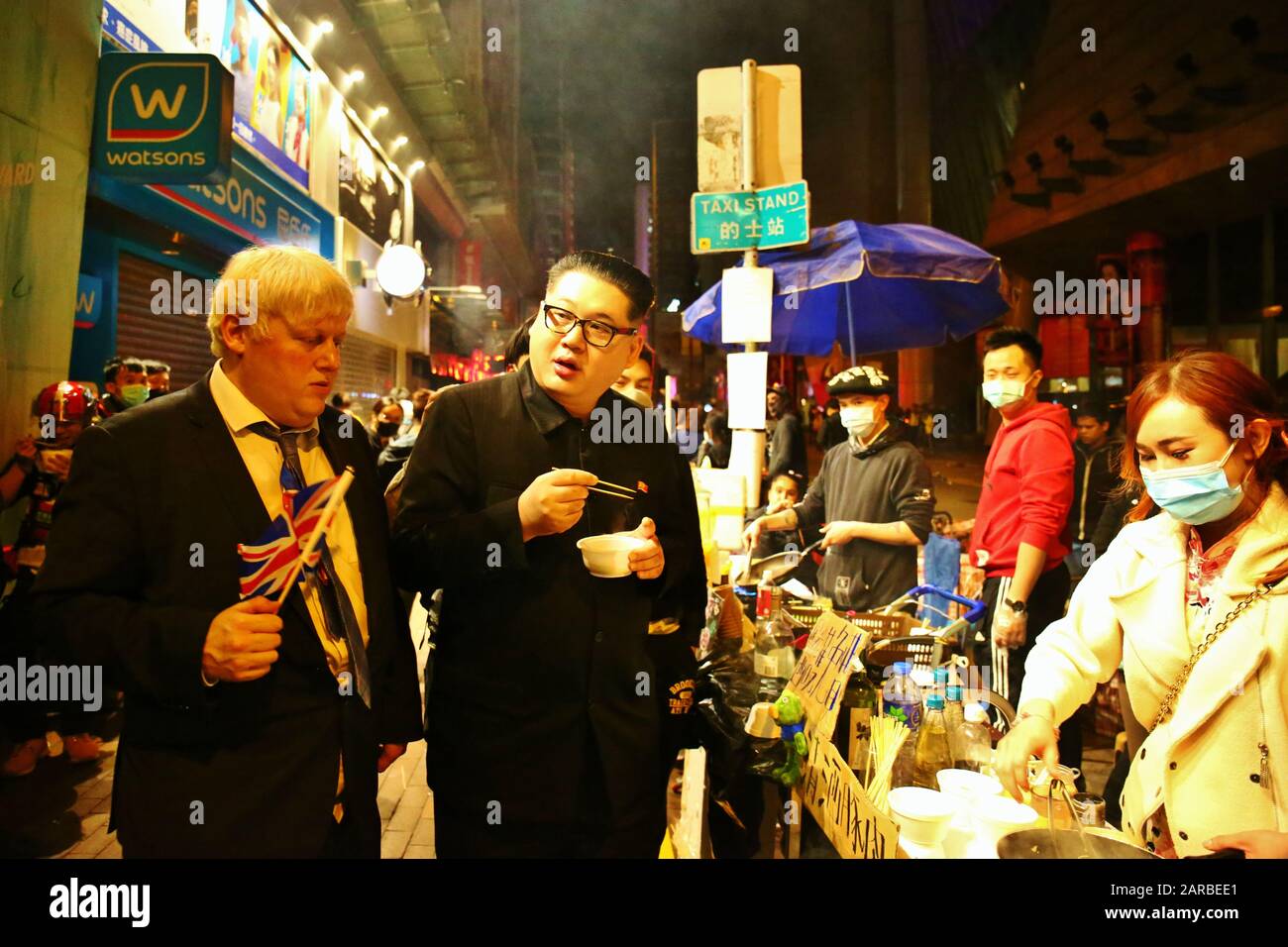 Hongkong. Januar 2020. Protestierende und Einheimische feiern den 4. Jahrestag der sogenannten Fischballrevolution im Bezirk Mongkok. Hier isst Boris Johnson Darsteller Drew Galdron Straßennahrung mit Kim Jong-un Imitator Howard X. Credit: Gonzales Photo/Alamy Live News Stockfoto