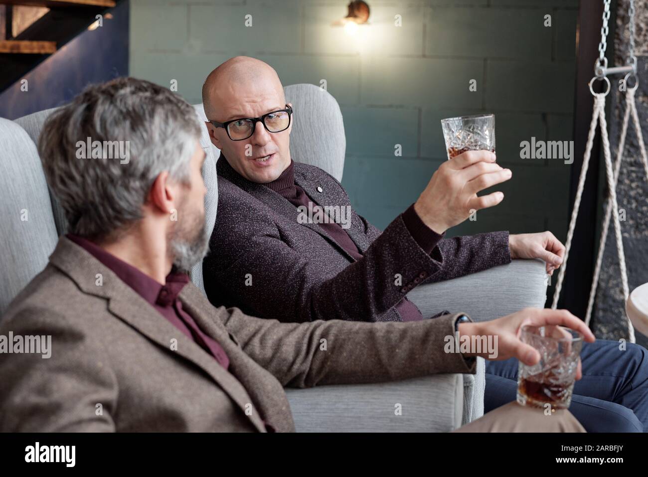 Besprechung der Geschäftsabläufe über ein Glas Whisky Stockfoto