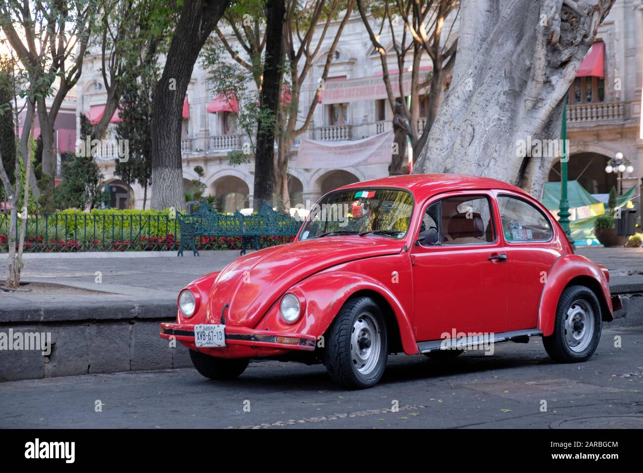 Roter klassischer VW-Käferwagen, der auf dem Stadtplatz im Zentrum von Puebla, Mexiko geparkt ist Stockfoto