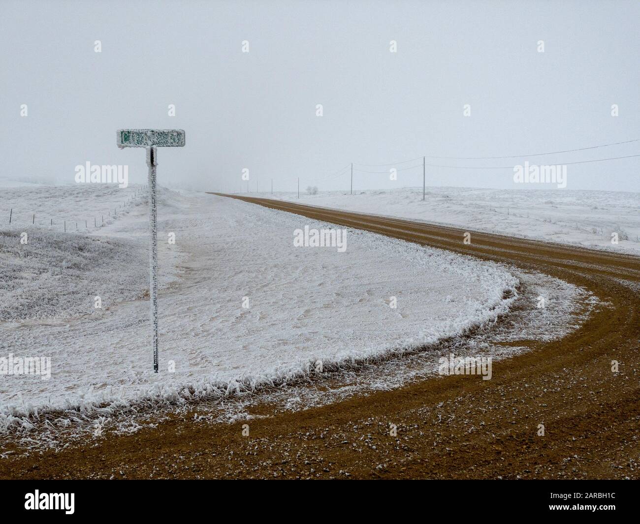 Kurvenreiche Straße durch eine Landschaft, die an einem bitterkalten Wintertag in North Dakota mit weißem Hochfrost überzogen ist, Konzept der Jahreszeiten Stockfoto