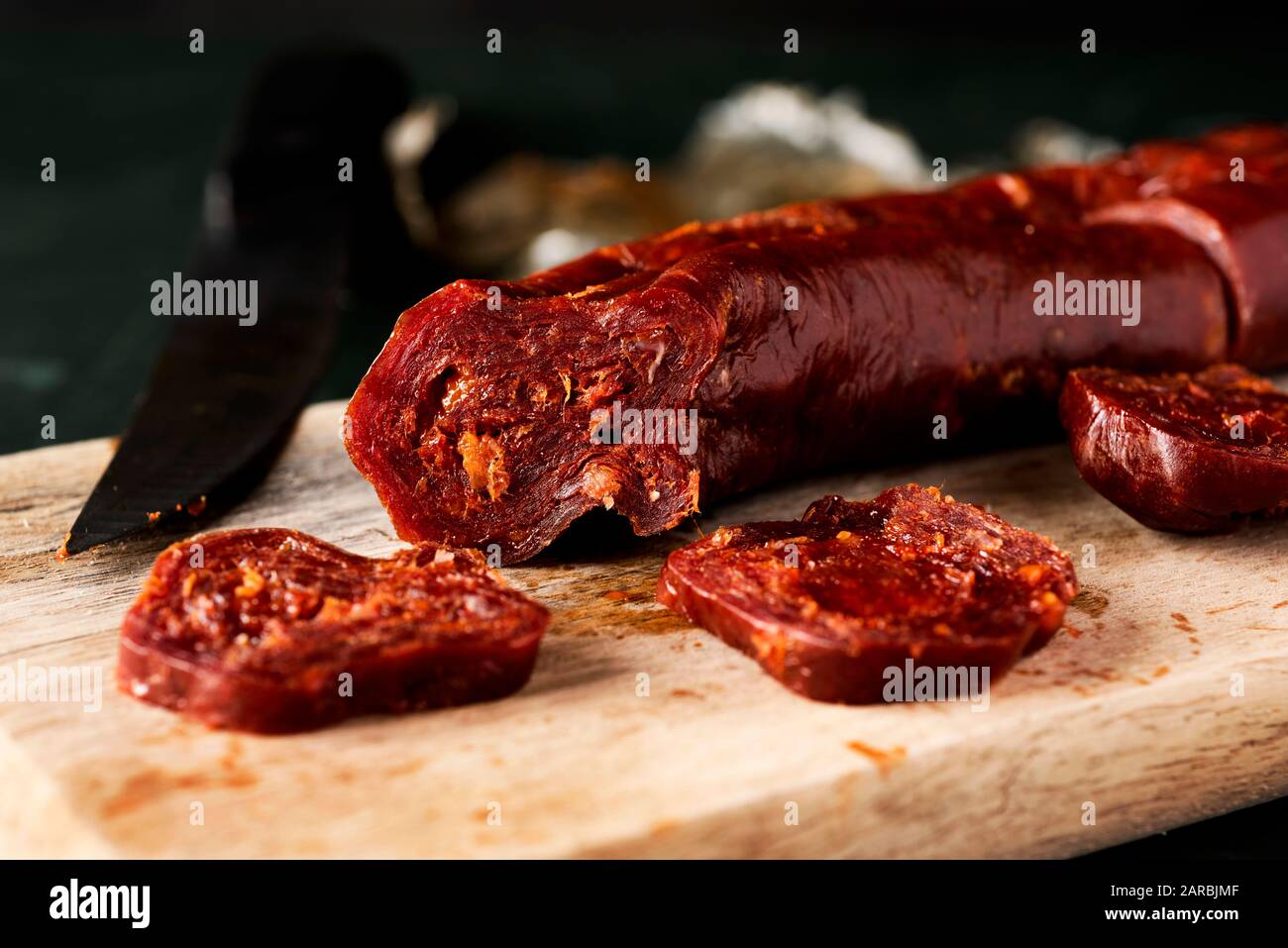 Nahaufnahme der einige Scheiben Chorizo, einem ausgehärteten Wurst aus Schweinefleisch, die typisch für Spanien, auf einer hölzernen Schneidebrett Stockfoto
