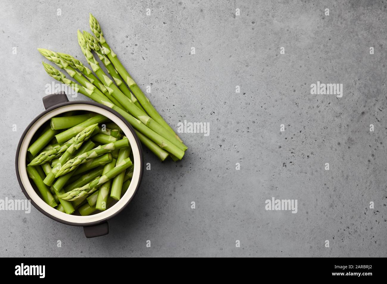 Frischer grüner Spargel auf grauem Betongrund Stockfoto