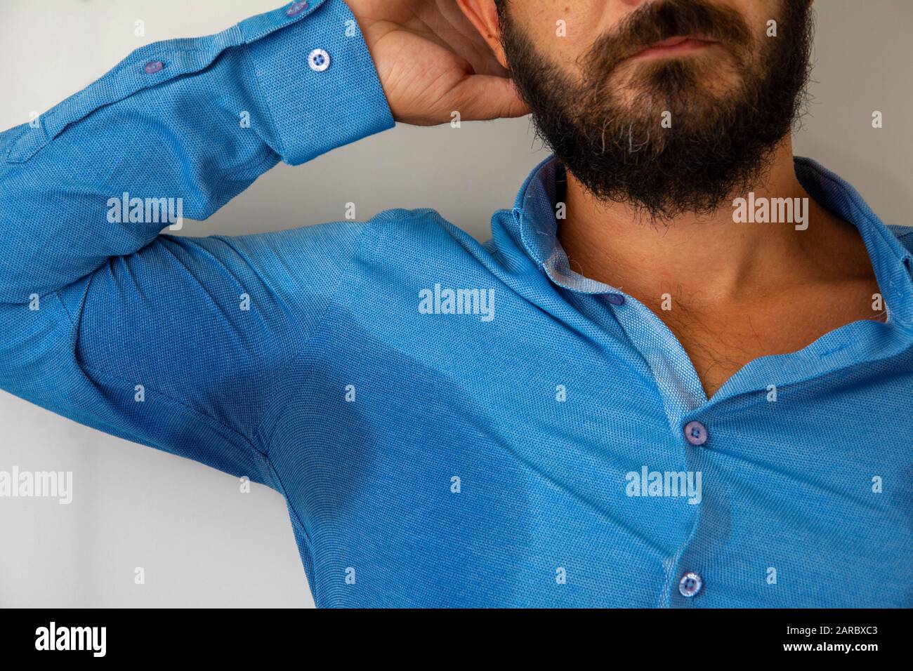 Armbrust schwitzte Mann in blauem Hemd Stockfoto