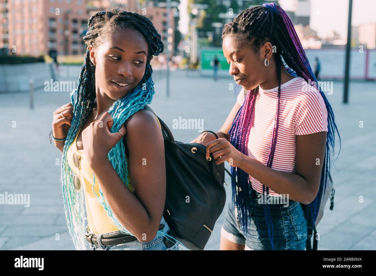 Junge schwarze Frau, die in ihre Ledertasche ihrer Schwester schaut und nach etwas sucht - nach einem Konzept suchen, suchen, sich ein Konzept angucken Stockfoto
