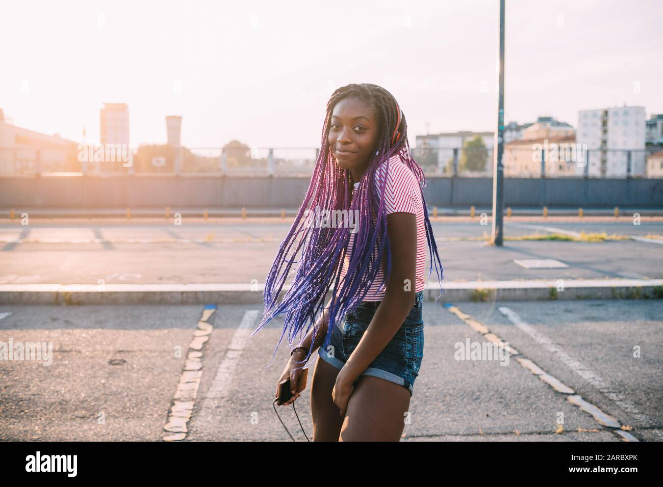 Junge schwarze schöne Frau im Freien Musikgenuss mit Smartphone - frei, entspannend, genießend Stockfoto