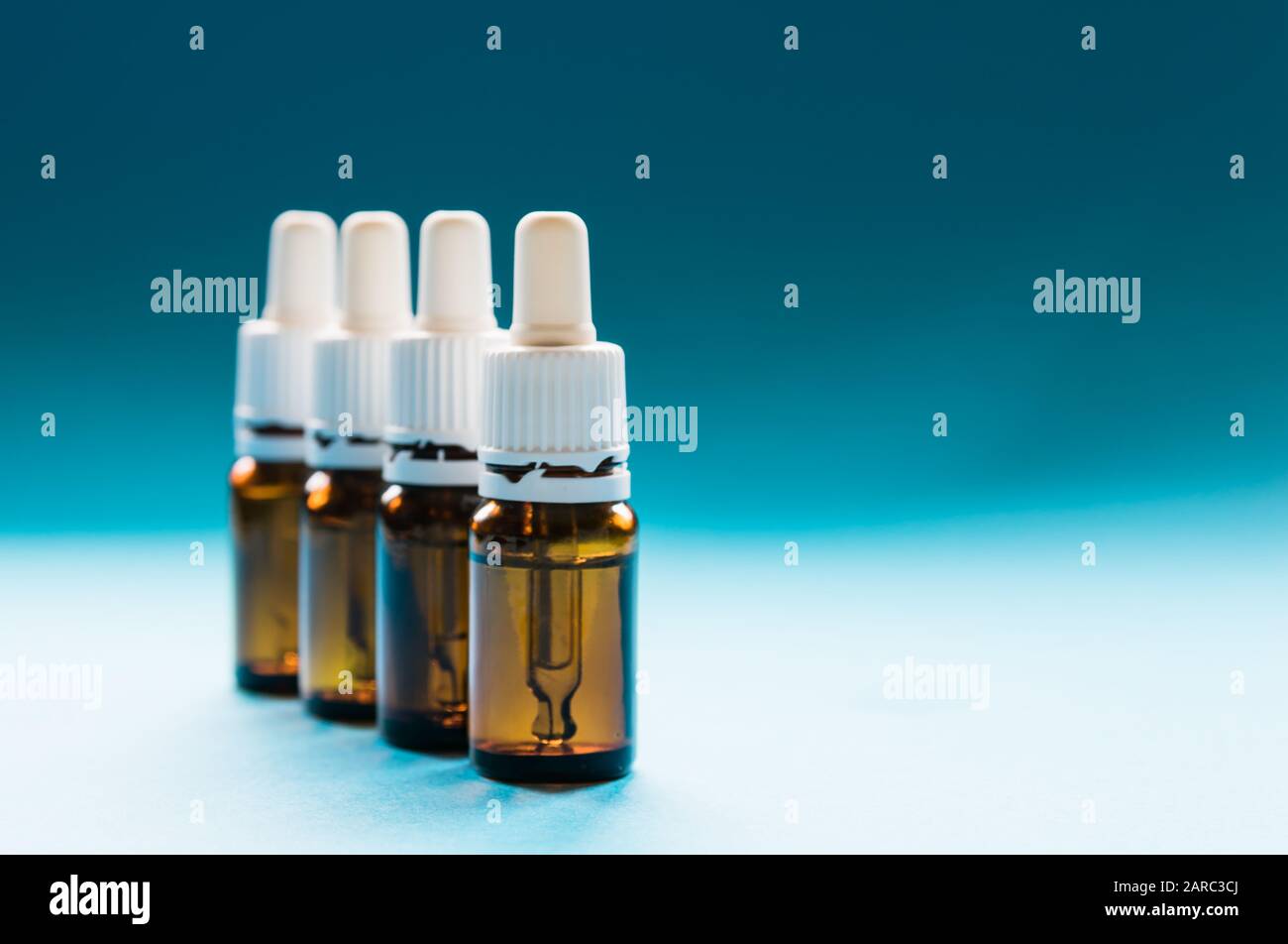 Kosmetologie, Glasflaschen mit Pipetten und Kosmetik auf blauem Hintergrund Stockfoto