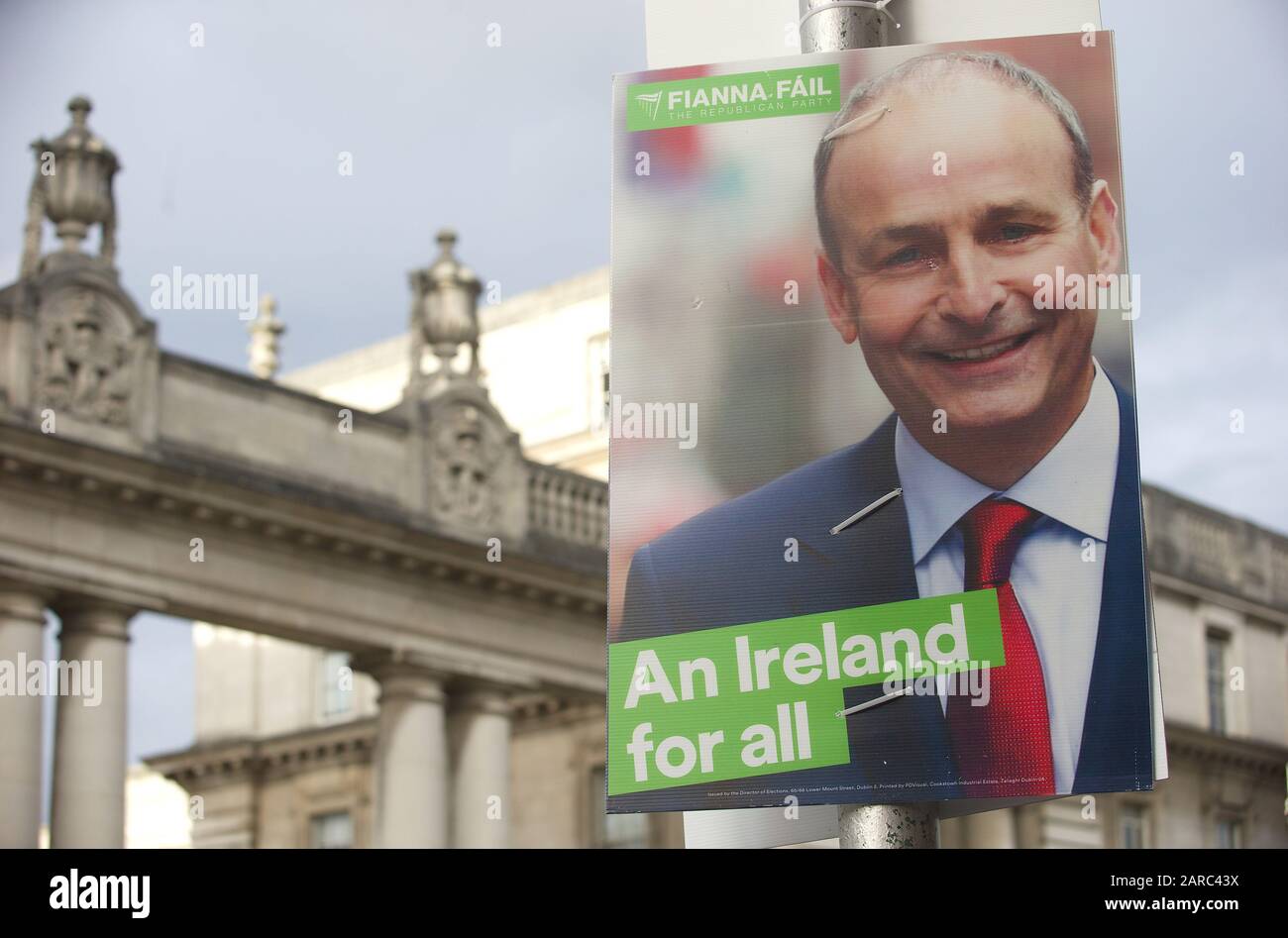 Die Menschen gehen mit politischen Plakaten außerhalb von Regierungsgebäuden in Dublin vorbei. Stockfoto