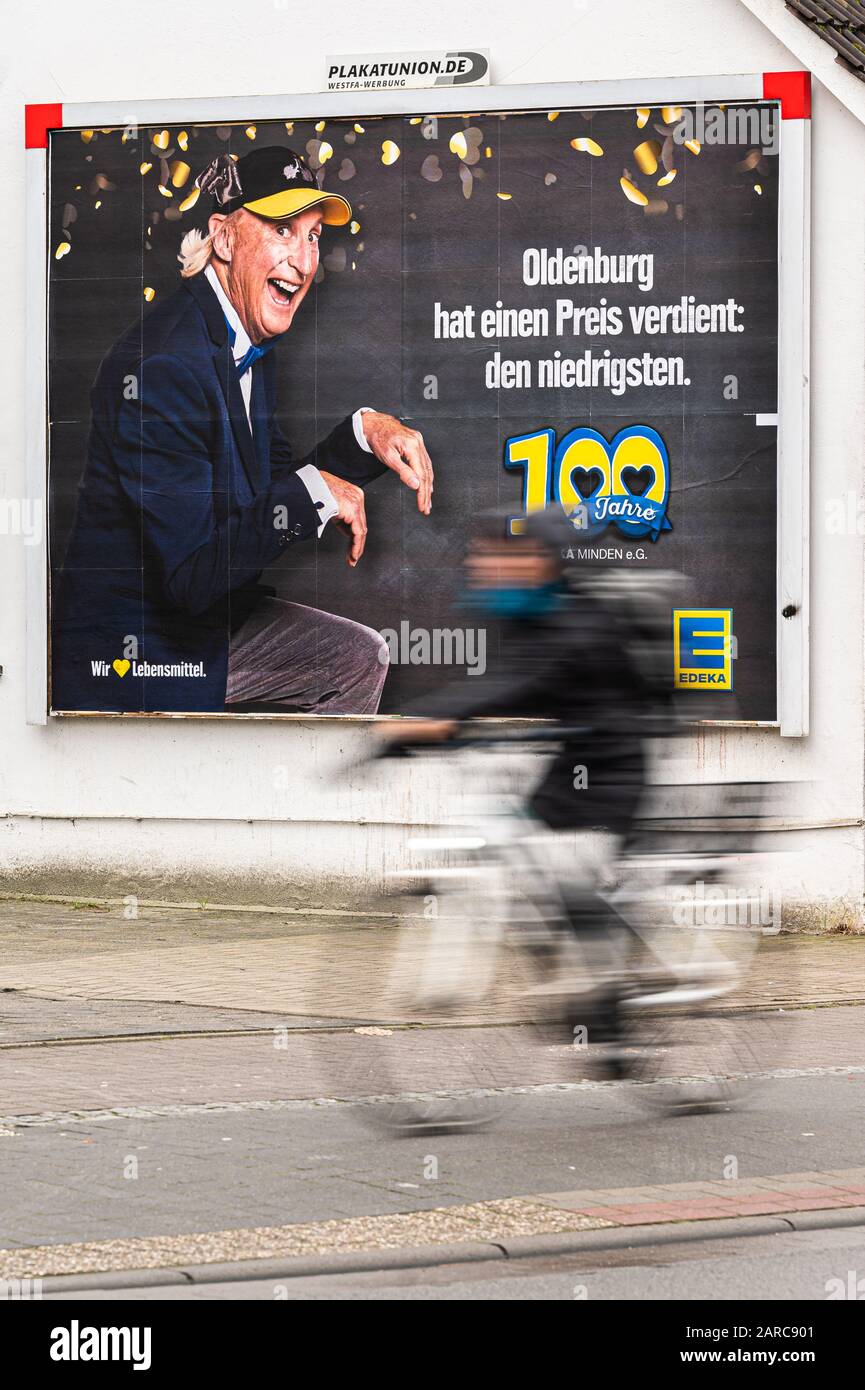 27. Januar 2020, Oldenburg: An einer Hauswand ist ein Werbeplakat der Firma Edeka zu sehen, auf dem der Komiker Otto Waalkes und der Slogan "Oldenburg hat einen Preis verdient: Die niedrigsten - 100 Jahre Edeka Mindener e.G." zu sehen sind (mit längerer Belichtungszeit gedreht). Die entsprechende Edeka-Anzeige in der Gemeinde Essen (Oldenburg) lautete "Essen hat sich einen Preis verdient: Den niedrigsten". Mit ihrer Werbekampagne für niedrige Preise hatte die Handelskette Edeka den Zorn hunderter Landwirte angefallen und unbeabsichtigt eine Debatte über faire Lebensmittelpreise ausgelöst. Foto: Mohssen Assanimoghaddam Stockfoto