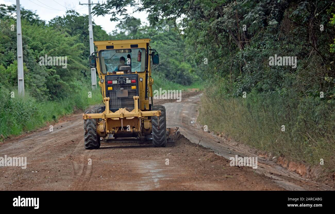 Straßenbaumaschine in Brasilien arbeitet auf Schotterstraße. Stockfoto
