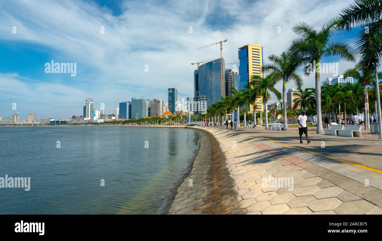 Luanda, ANGOLANISCHER Zeit - 15. Dezember 2019: Menschen, die an einem sonnigen Tag in der Bucht von Luanda spazieren gehen. Redaktionelle Illustration. Stockfoto
