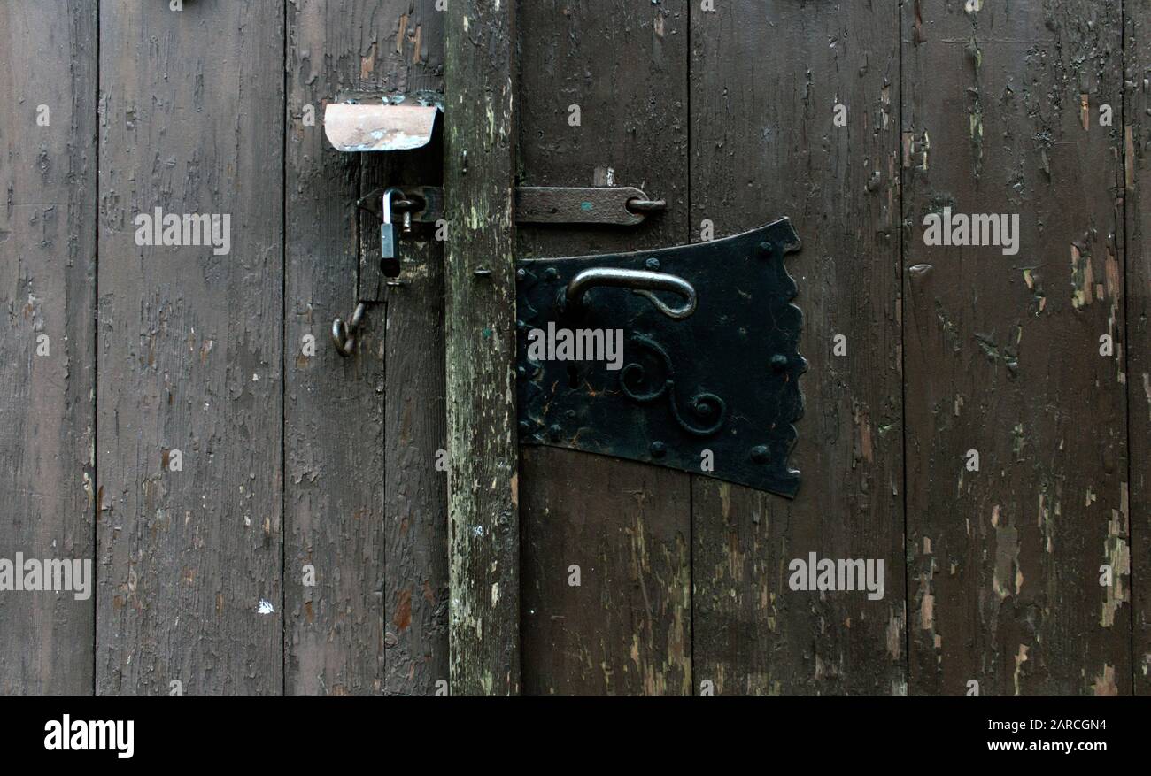 Nahaufnahme alter und neuer Eisenschlösser an der Holztür. Technologischer Wandel, Sicherheitskonzepte. Stockfoto